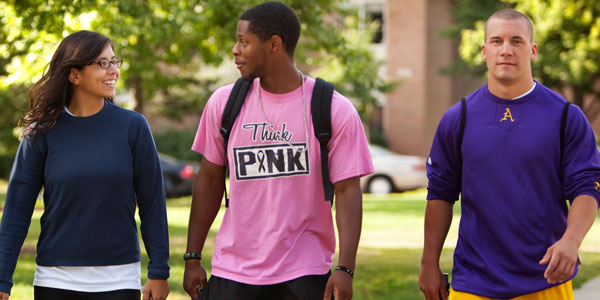 Three Albion College students walking on the Quad.