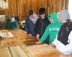 Students inspecting the forest products at Appalachian Sustainable Development's mill. One effort is to market as "character wood" material that otherwise would be considered waste.