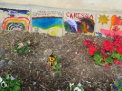 Tiles created by children in the complex adorn the base of a demonstration straw bale pavilion in the complex