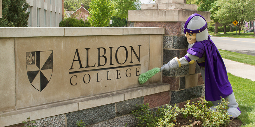 Brit Briton cleaing the Albion College sign. 