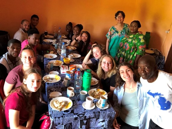 French students in Cameroon eating together at a table. 