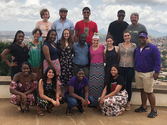 French students in Cameroon posing with the city behind them. 