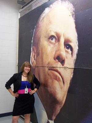Colleen Ouendag, '12, stands next to a billboard of Gerald R. Ford kept in collections at the Ford Presidential Museum in Grand Rapids.