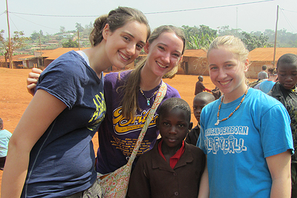 Melissa Woodard, Kim Hagel, and Alyssa Heilman with a girl they met at one of the schools the Albion group visited.