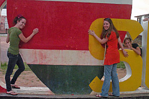 Meyer, Kirsch and Kaisler with part of a large "I Love Suriname" sign in the capital.