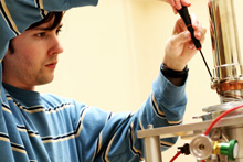 An Albion College physics student adjusts equipment in the lab.