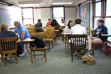 Albion residents sit with students in a classroom. 