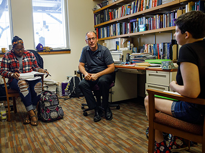 Dr. Christopher Rohlman, professor of biochemistry, meets with students in his Putnam Hall office.